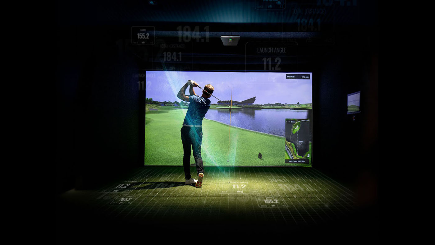 A Tee Box member practicing their swing on an indoor virtual golf simulator.