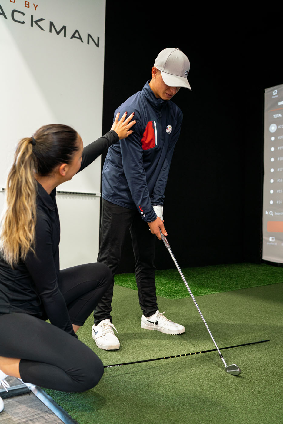 Tee Box golf teachers helping a younger golfer improve his performance.