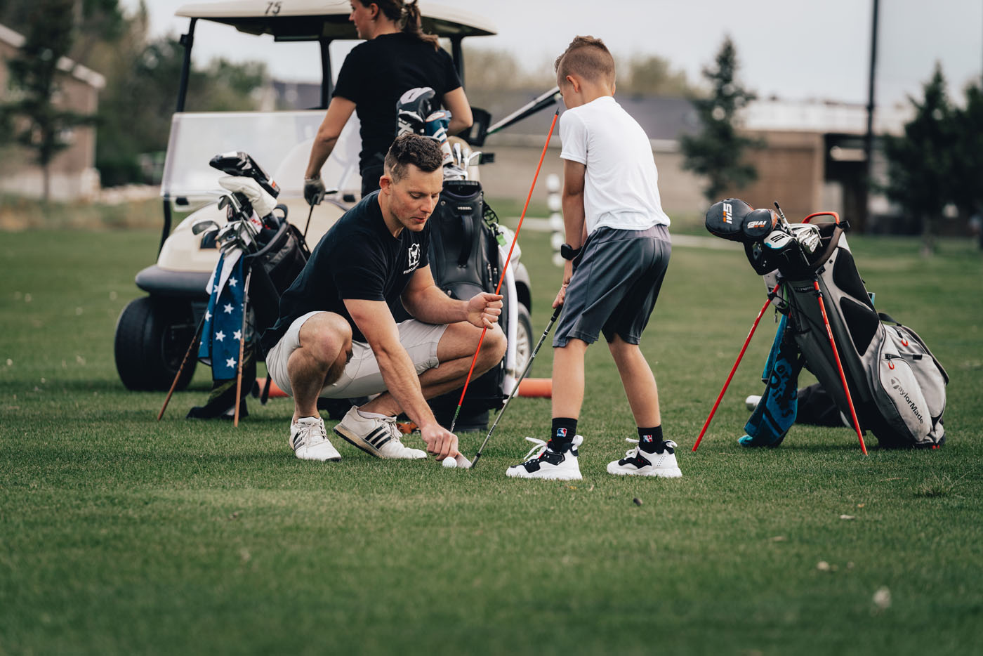 A Tee Box employee working with a group of kids on a golf course in Avon, IN.